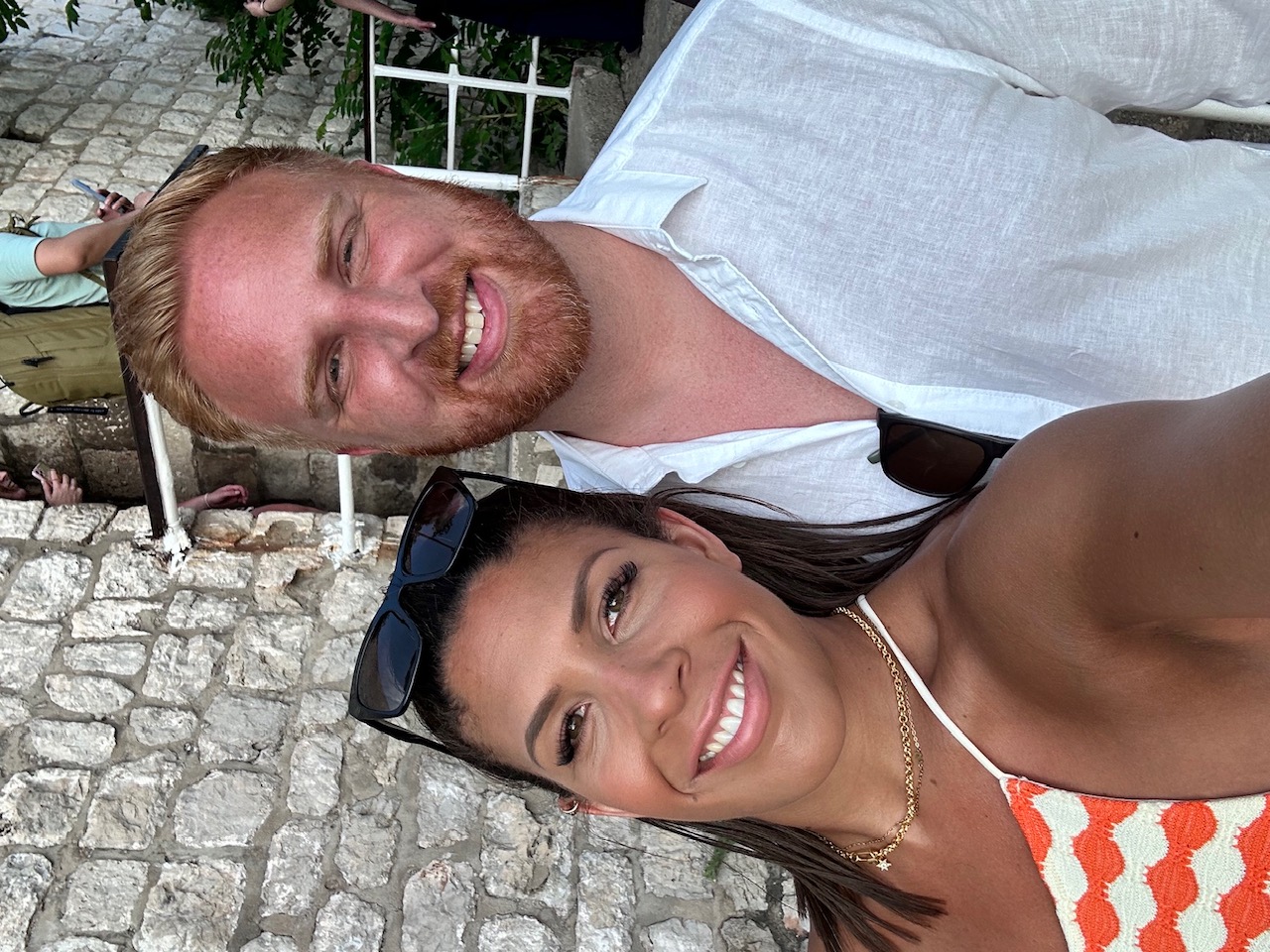Tim and Sophie smiling beside an old stone wall