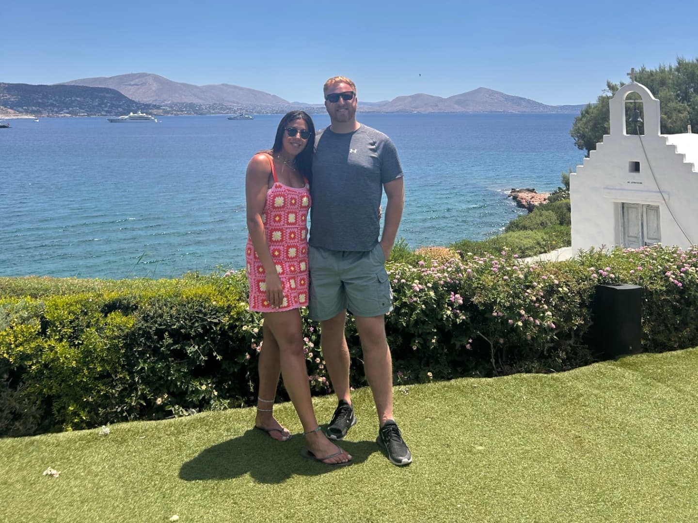 Tim and Sophie at the Island Athens Riviera, with the chapel and sea behind them